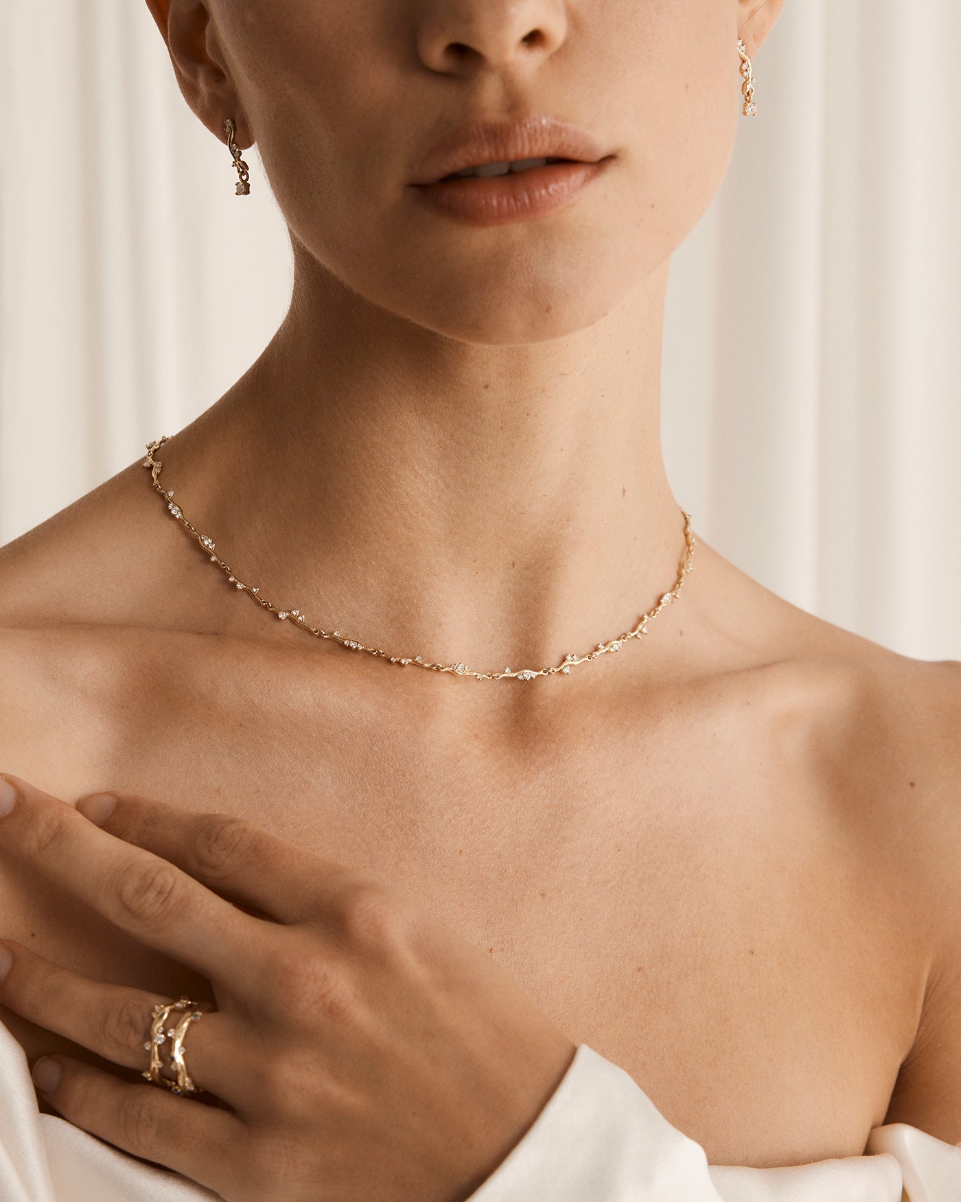Photo of Ember Necklace on model, wearing a white dress and matching diamond earrings