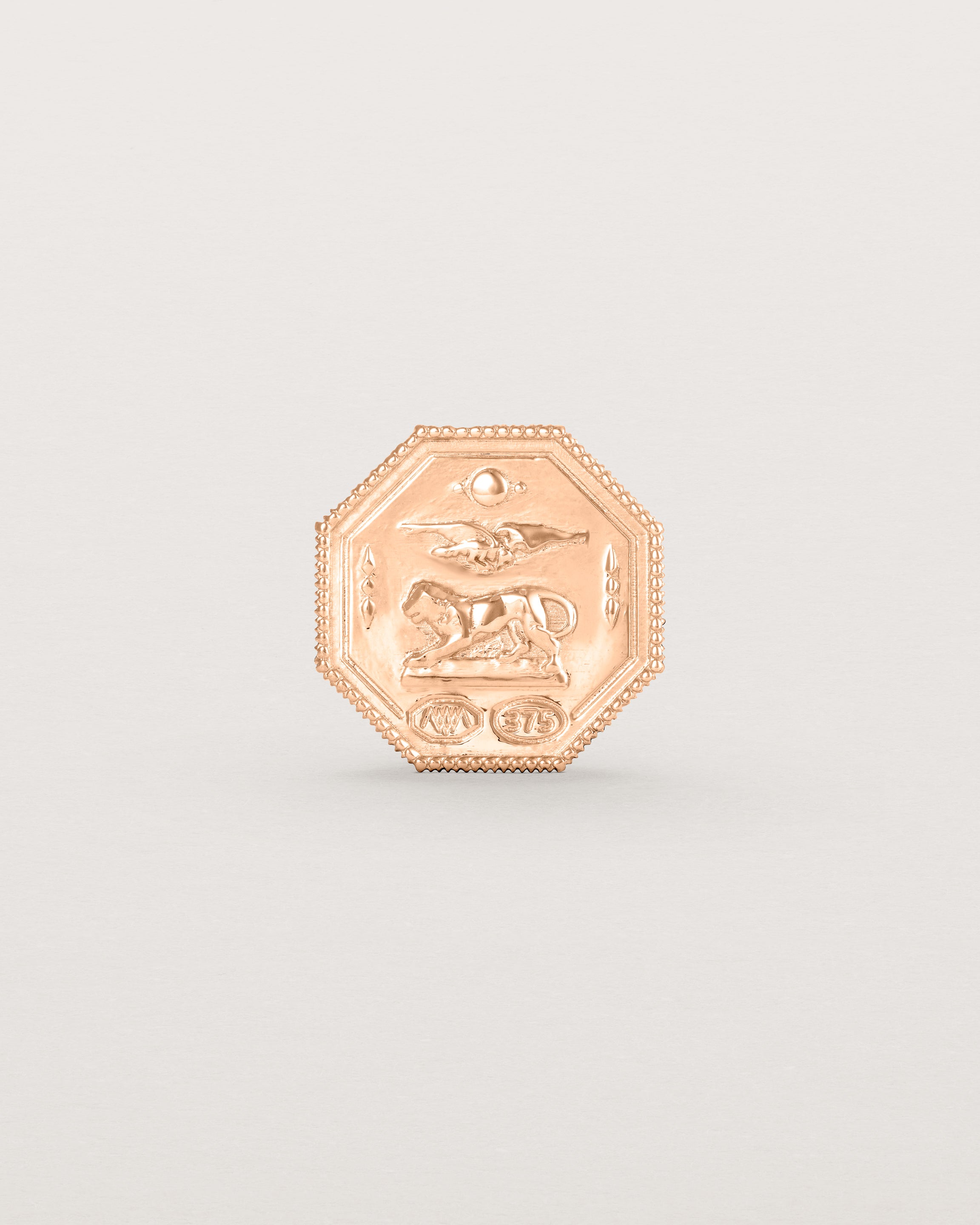 Rose gold six pence coin engraved with a crest and initials