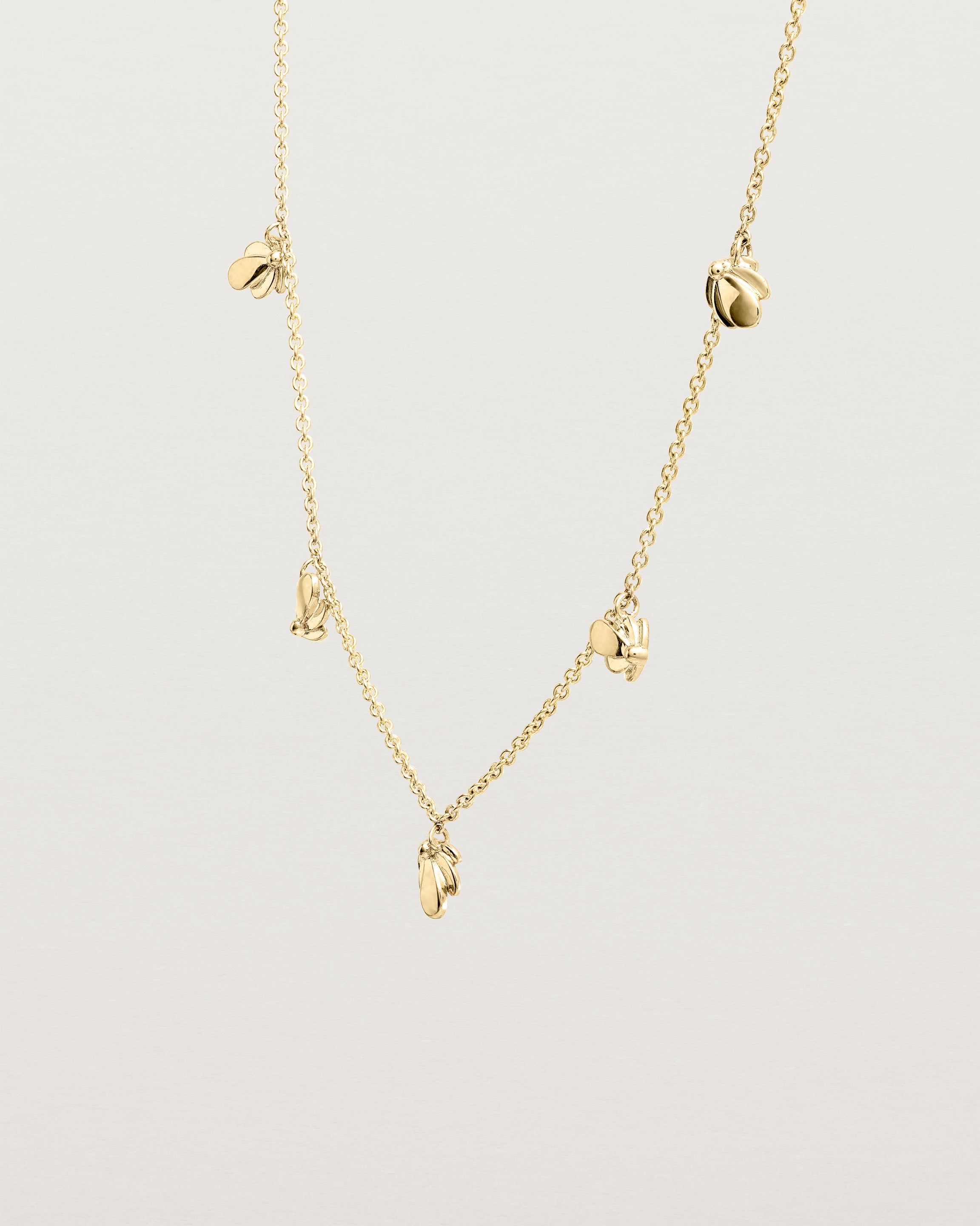 Angled view of the Aeris Charm Necklace in yellow gold.