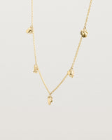 Angled view of the Aeris Charm Necklace in yellow gold.