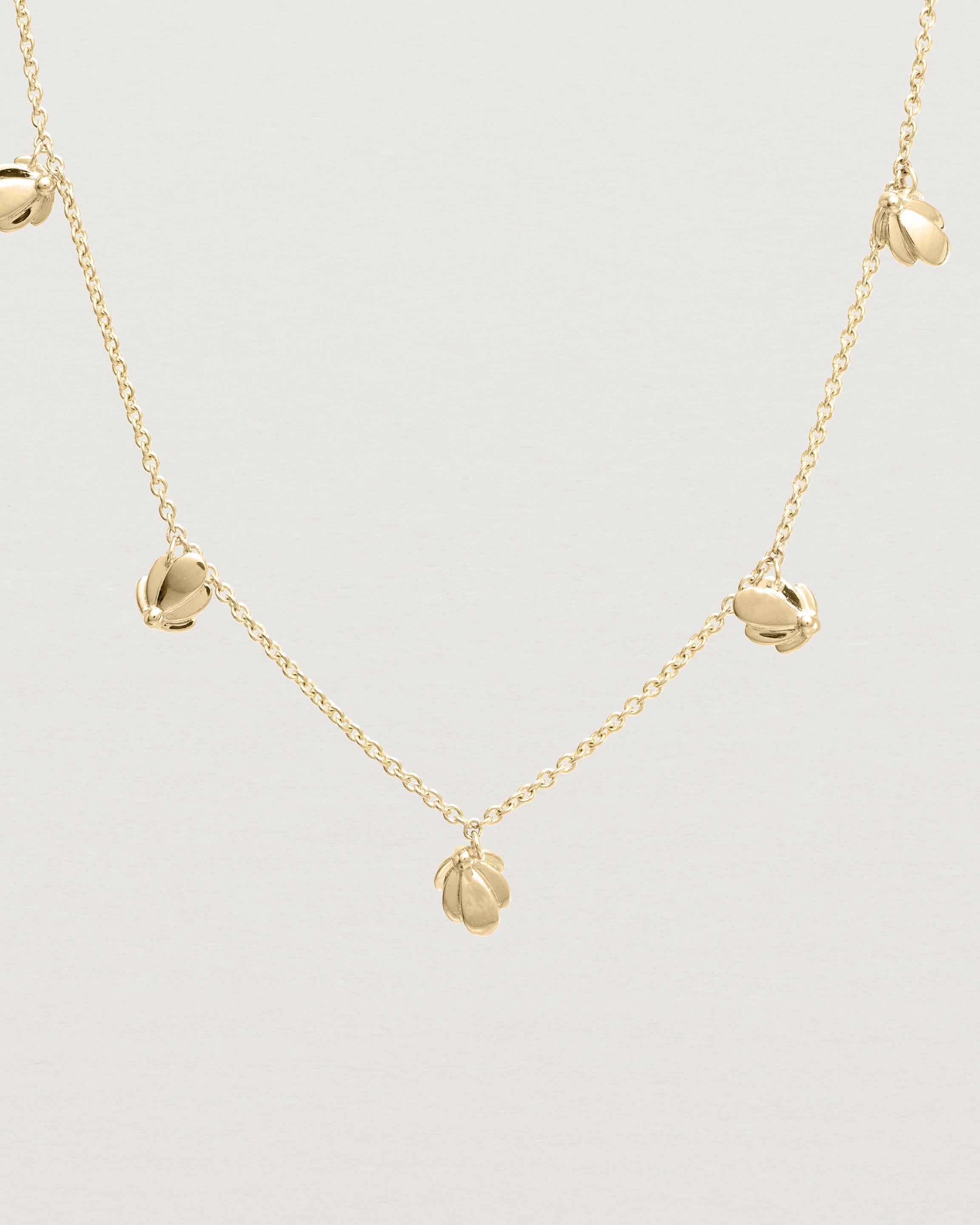 Close up view of the Aeris Charm Necklace in yellow gold.
