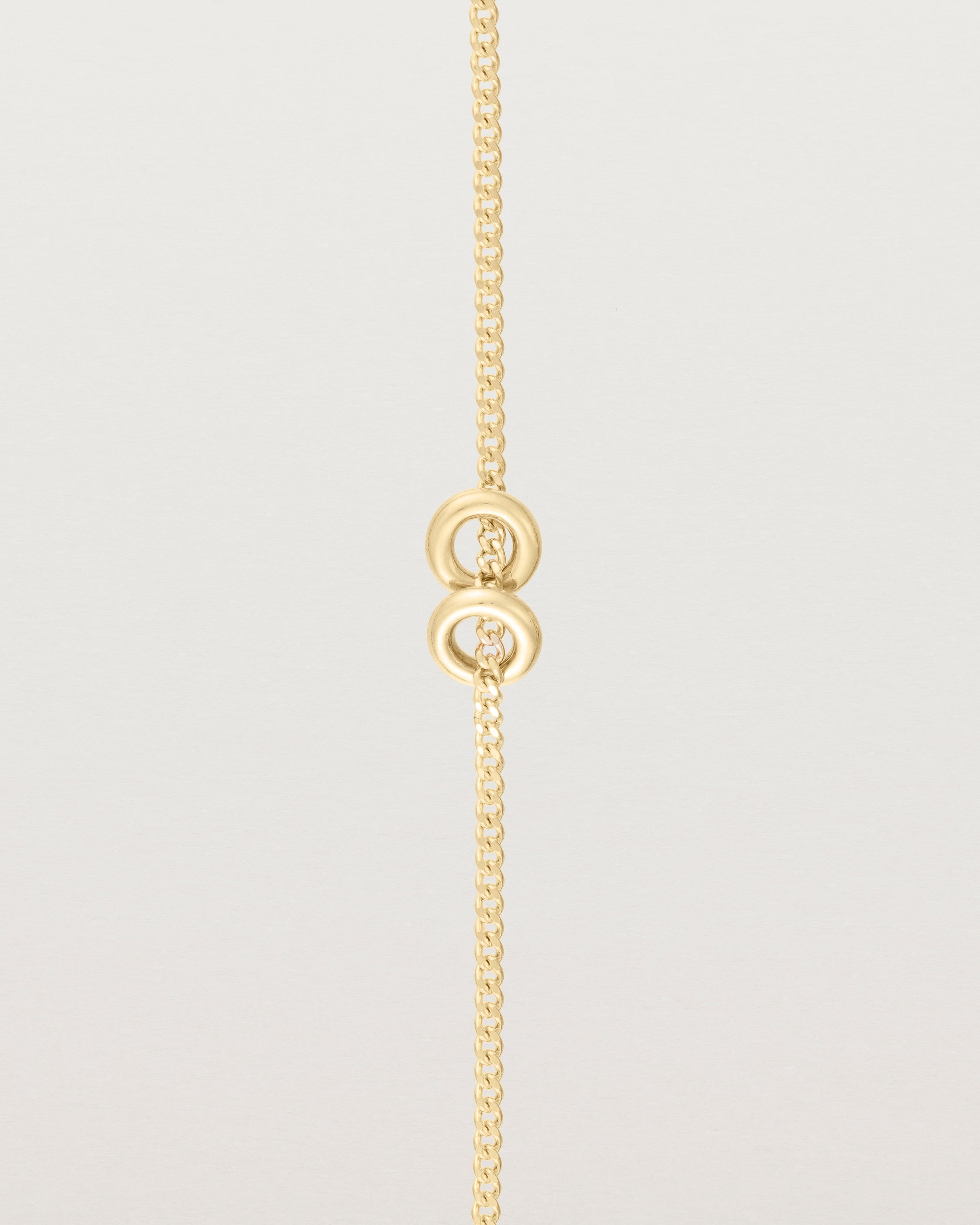 close up view of Aether bracelet featuring two round charms in yellow gold