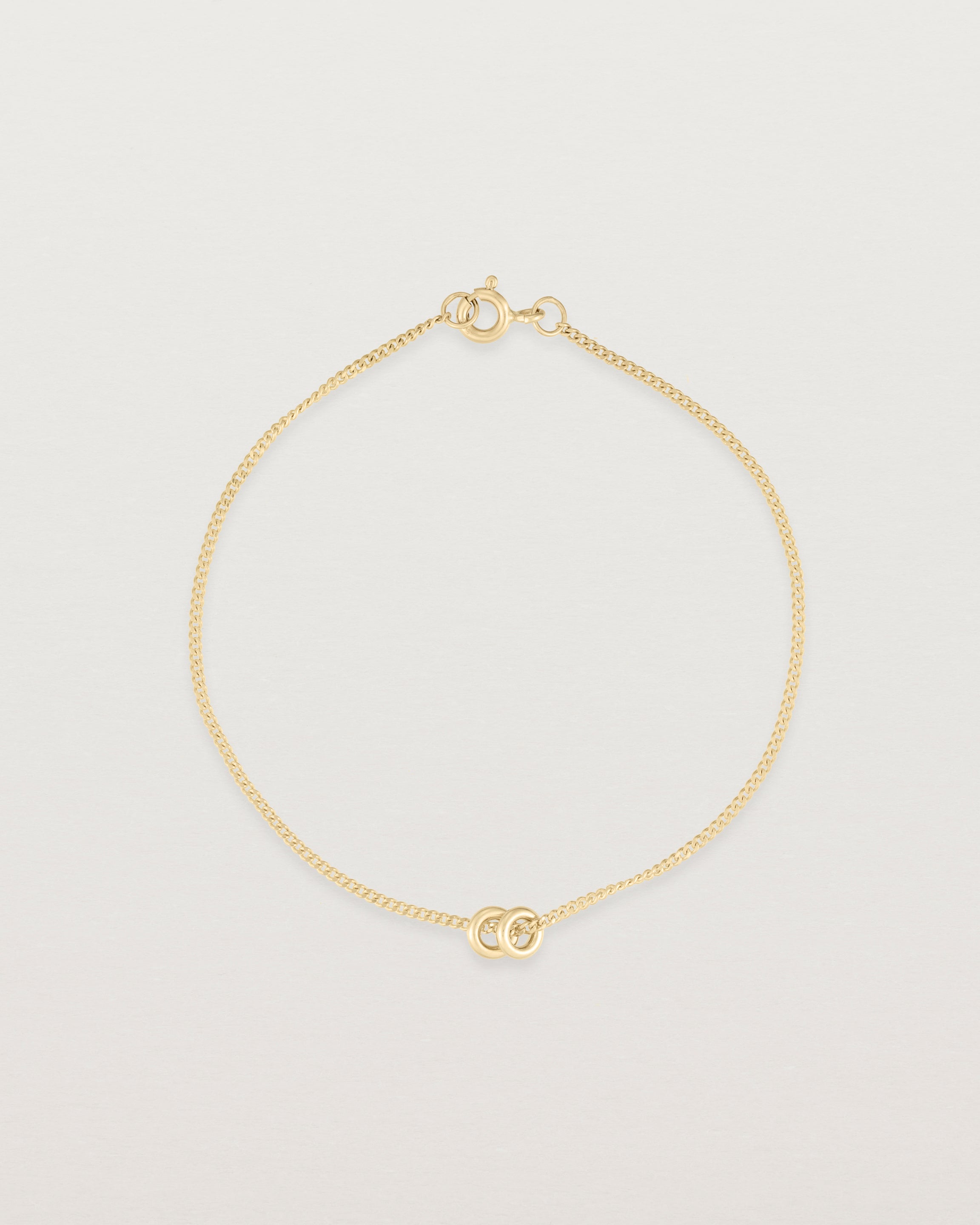 top down view of Aether bracelet featuring two round charms in yellow gold