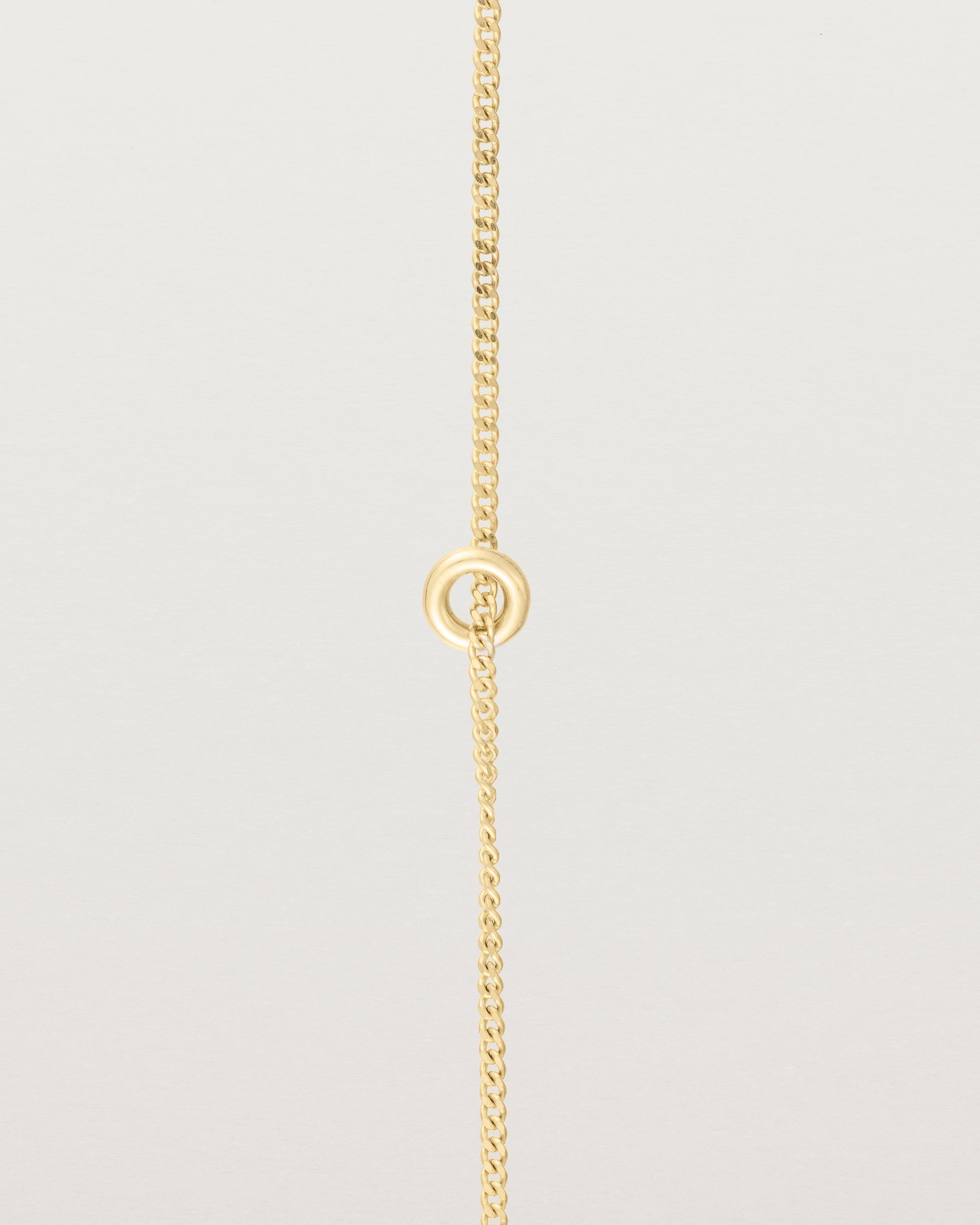 View of Aether Bracelet featuring one round charm in yellow gold.