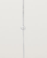 close up view of the Aether Bracelet showing one round charm in sterling silver
