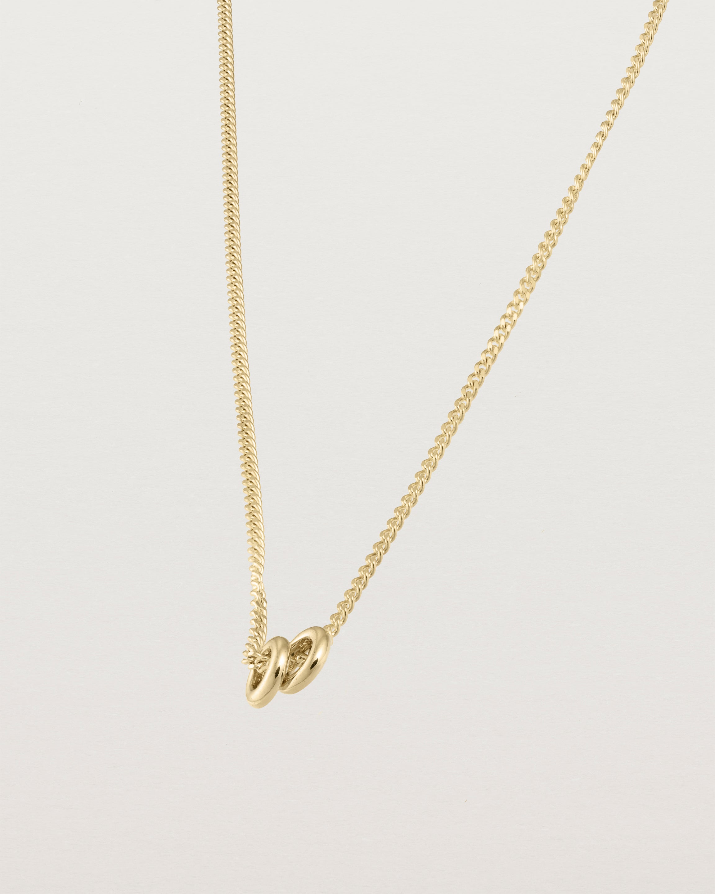 Aether necklace showing two round charms in yellow gold