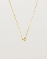 close up of Aether necklace showing two round charms in yellow gold