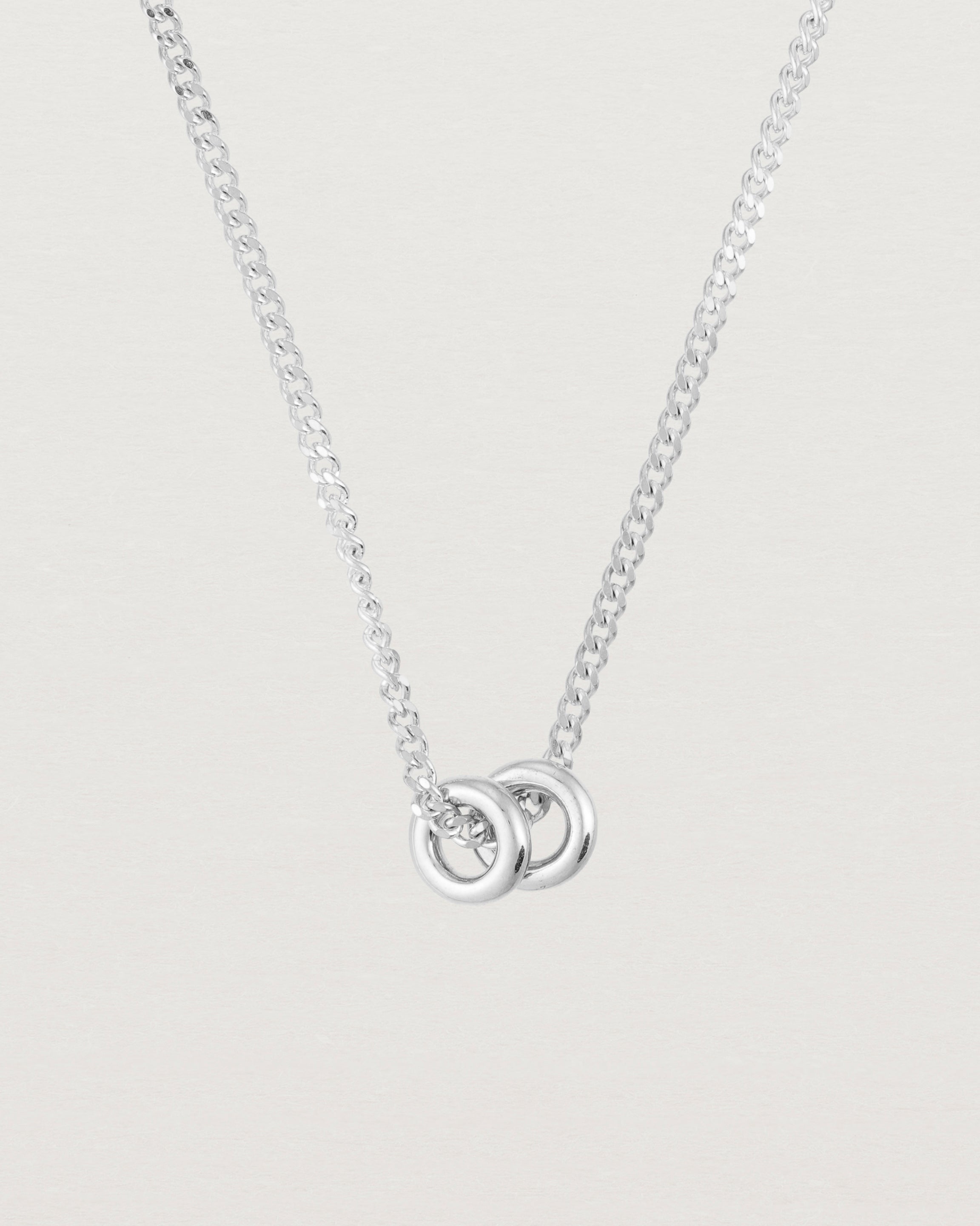 Close up of Aether necklace in white gold with two round charms