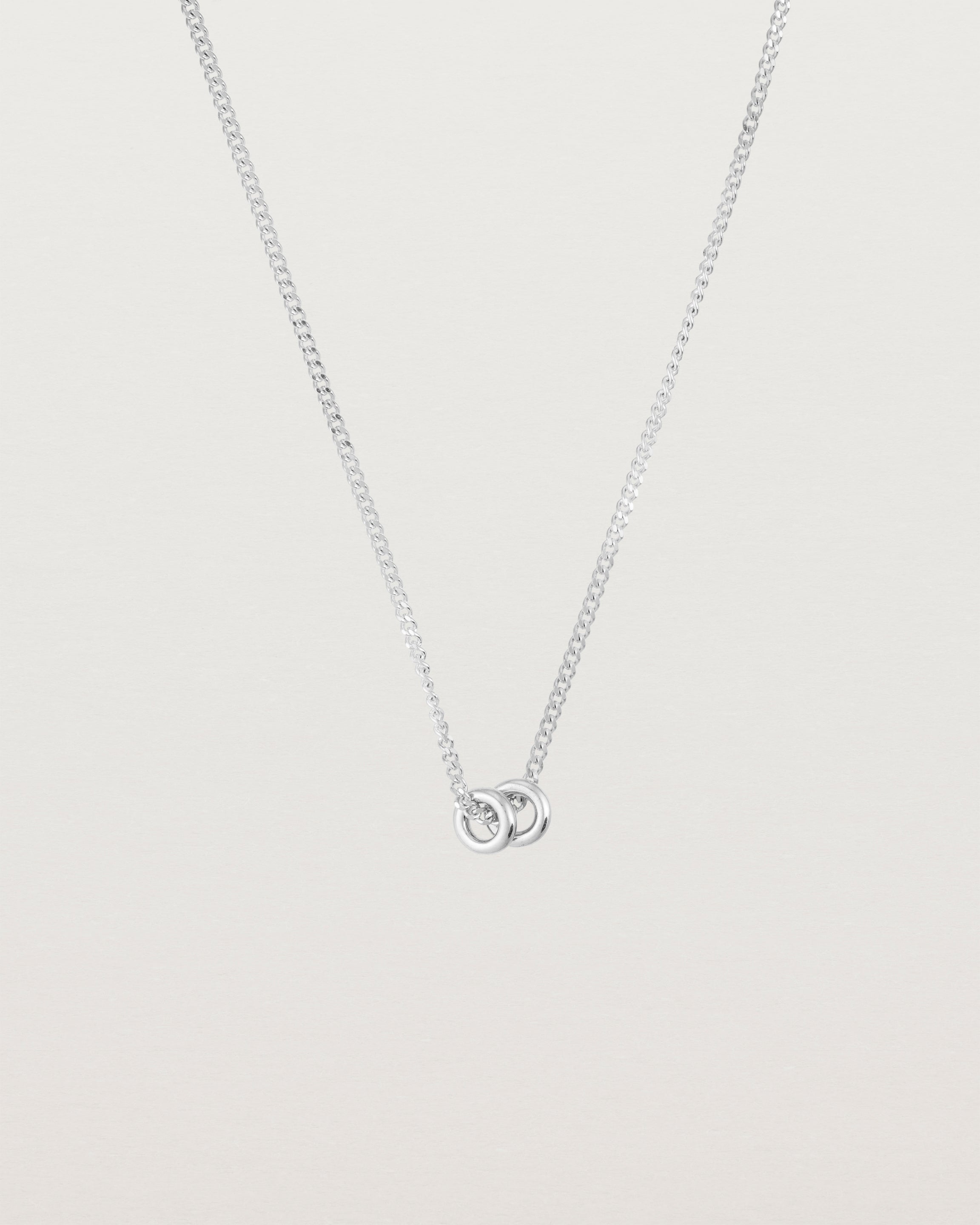 Pulled back image of the. Aether necklace in white gold with two round charms