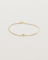 A fine yellow gold chain bracelet featuring a square circular charm