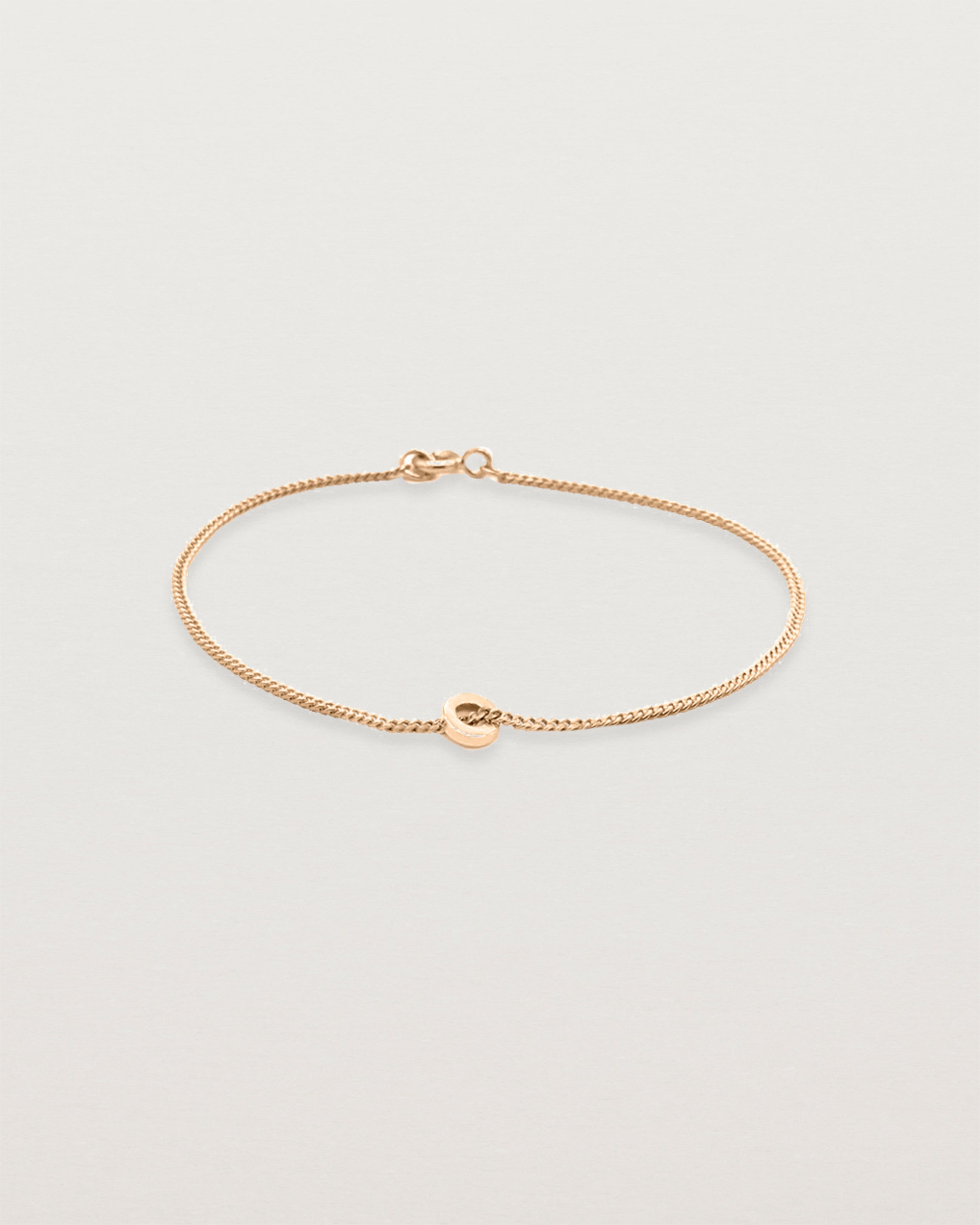 A fine rose gold chain bracelet featuring a rose gold circular charm