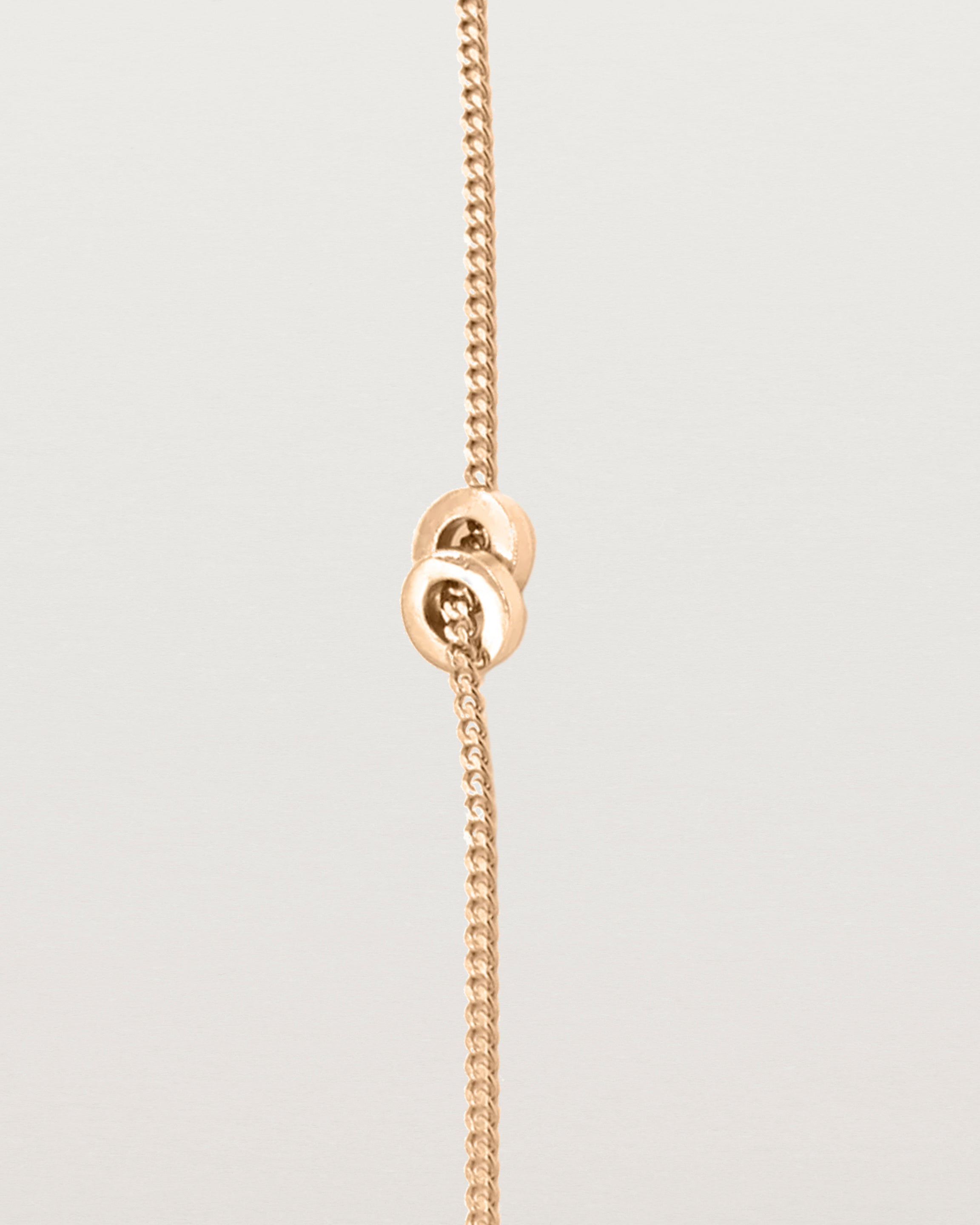 A fine rose gold chain bracelet featuring a rose gold circular charm