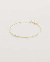 A yellow gold chain bracelet featuring a single white old cut diamond