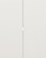 A white gold chain bracelet featuring a single white old cut diamond