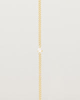 A yellow gold chain bracelet featuring a single white old cut diamond