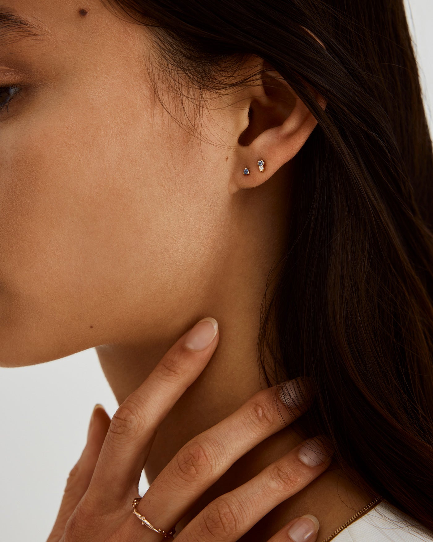 A woman wearing the Aiona Studs in Pale Blue Sapphires