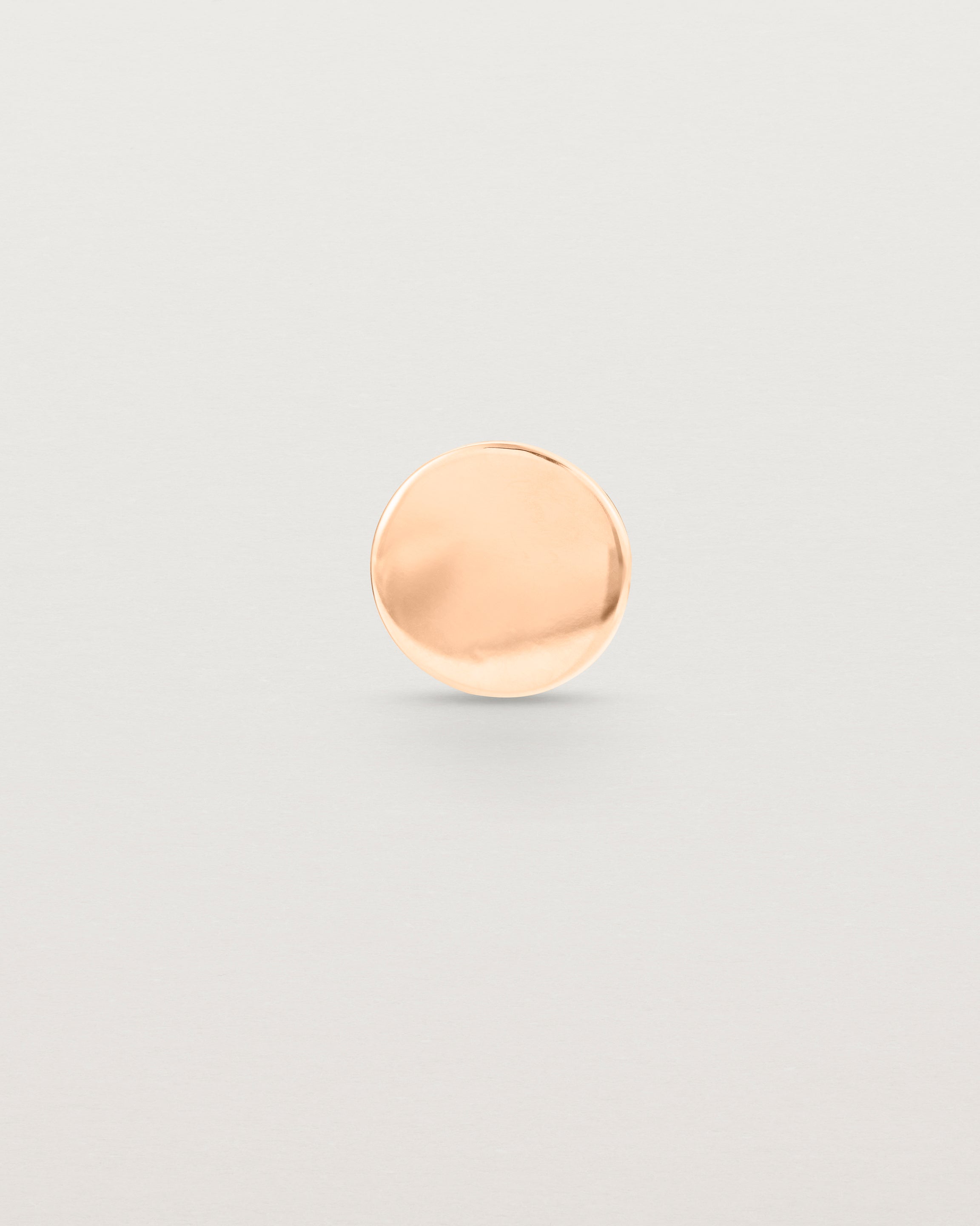 A round rose gold lapel pin