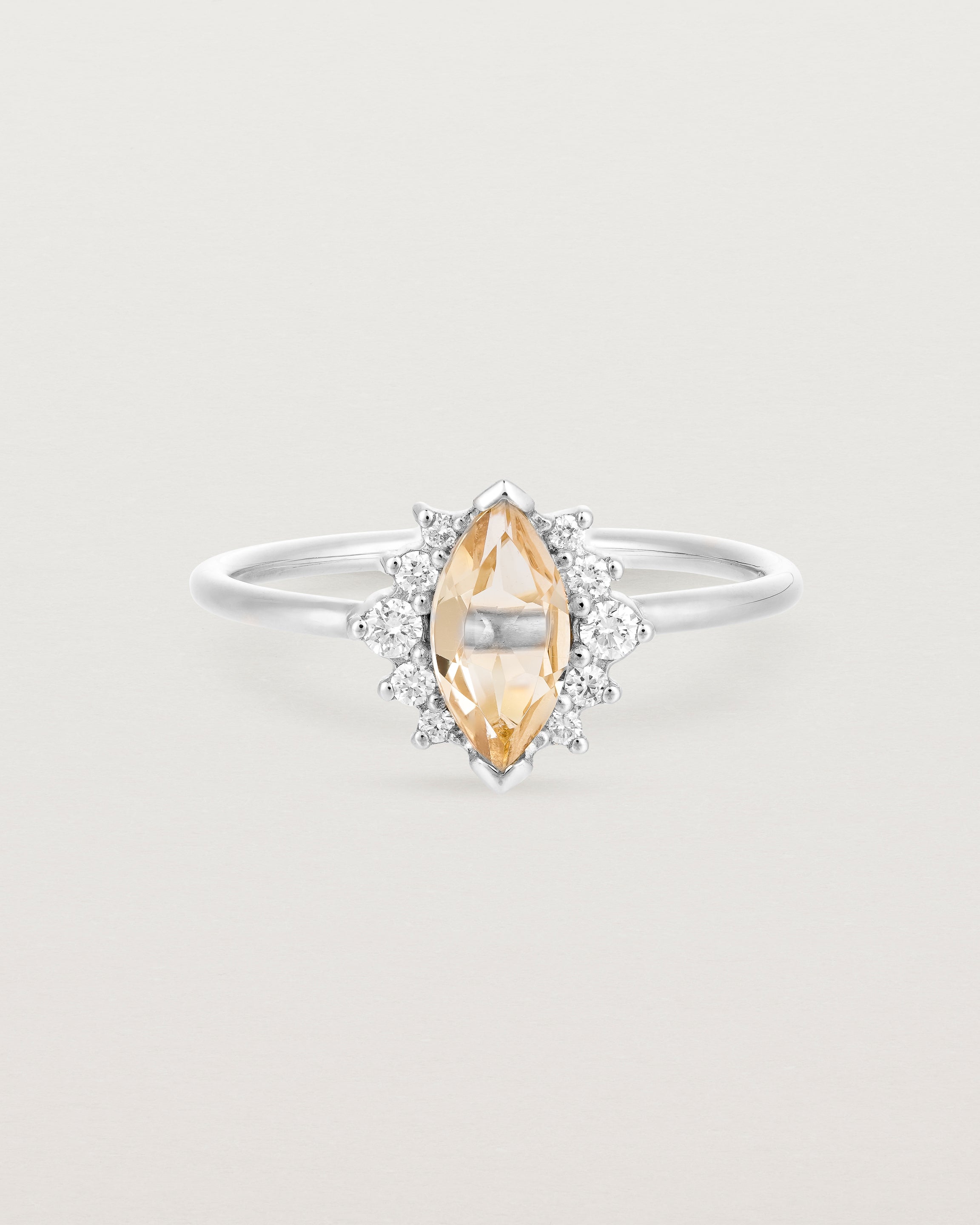 A white gold ring featuring a marquise champagne quartz with a halo of white diamonds