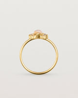 A yellow gold ring featuring a marquise champagne quartz with a halo of white diamonds