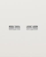 A pair of small silver rectangle studs featuring two white diamonds set in the centre