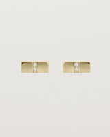 A pair of small yellow gold rectangle studs featuring two white diamonds set in the centre