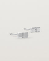 A pair of small silver rectangle studs featuring two white diamonds set in the centre