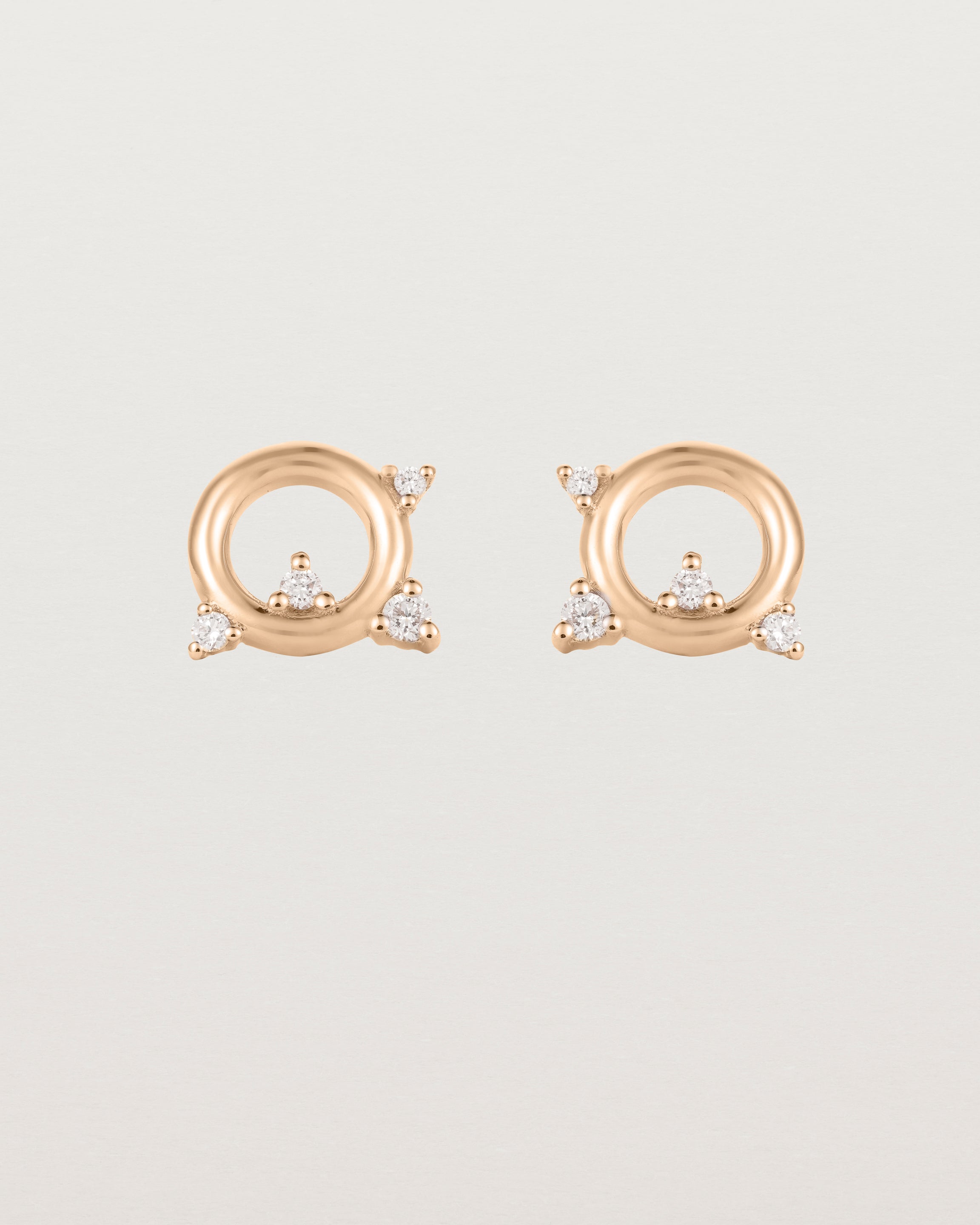 A pair of circular rose gold studs with four white diamonds