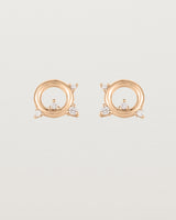 A pair of circular rose gold studs with four white diamonds