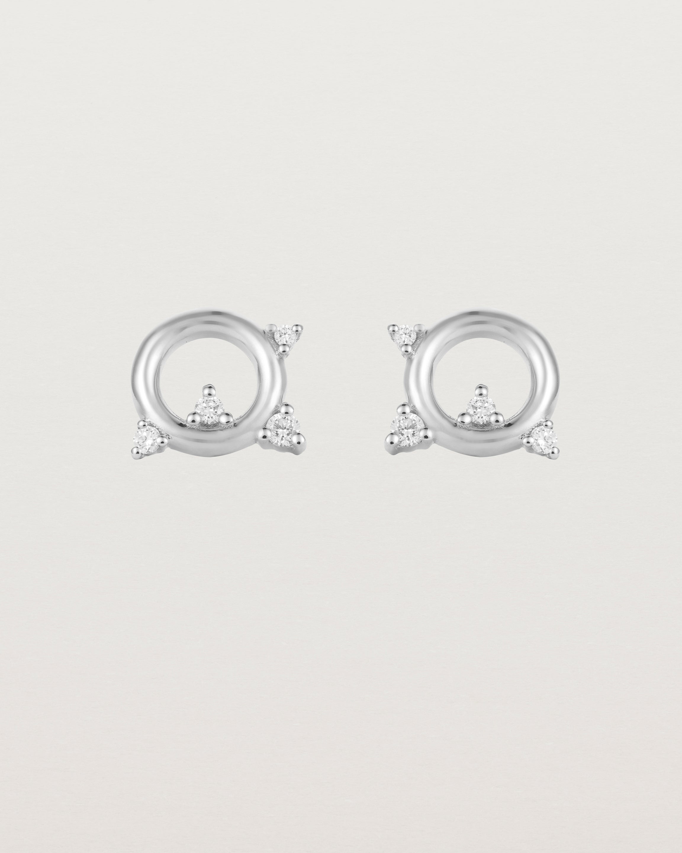 A pair of circular sterling silver studs with four white diamonds