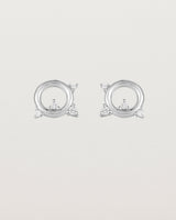 A pair of circular sterling silver studs with four white diamonds