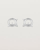 A pair of circular sterling silver studs with four white diamonds