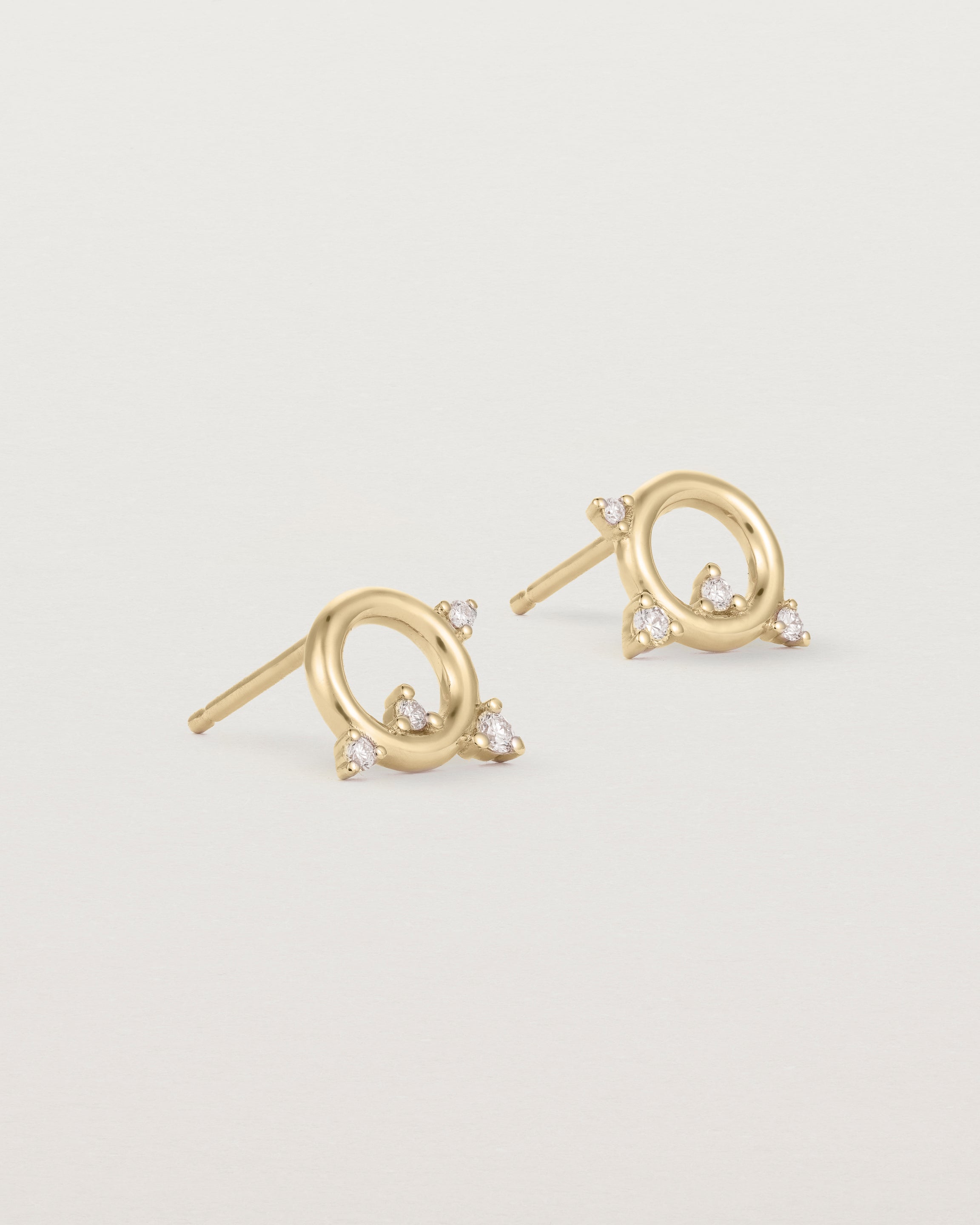 A pair of circular yellow gold studs with four white diamonds