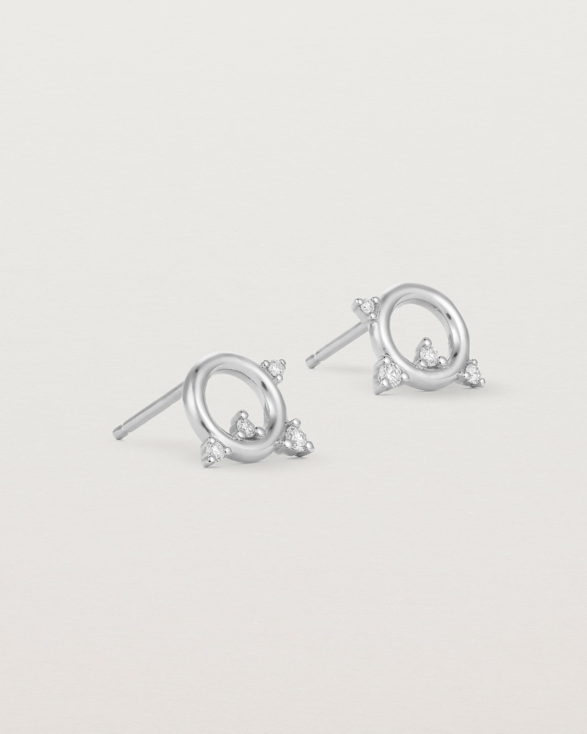 A pair of circular sterling silver studs with four white diamonds