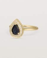 side view pear halo ring featuring a pear cut australian blue sapphire and a halo of white diamonds in yellow gold