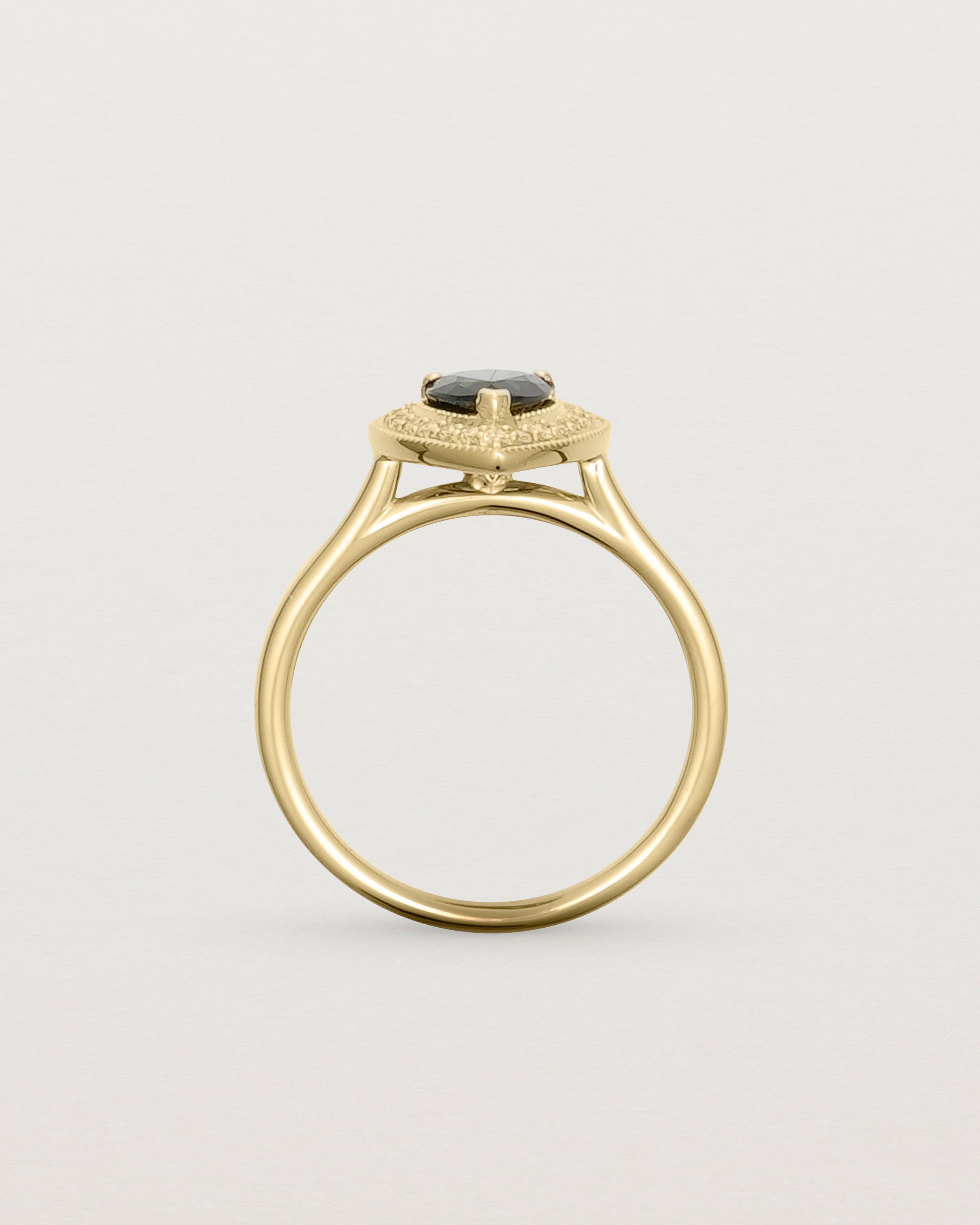 standing view pear halo ring featuring a pear cut australian blue sapphire and a halo of white diamonds in yellow gold