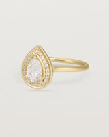 Side view pear halo ring featuring a pear cut clear laboratory grown diamond and a halo of white diamonds in yellow gold