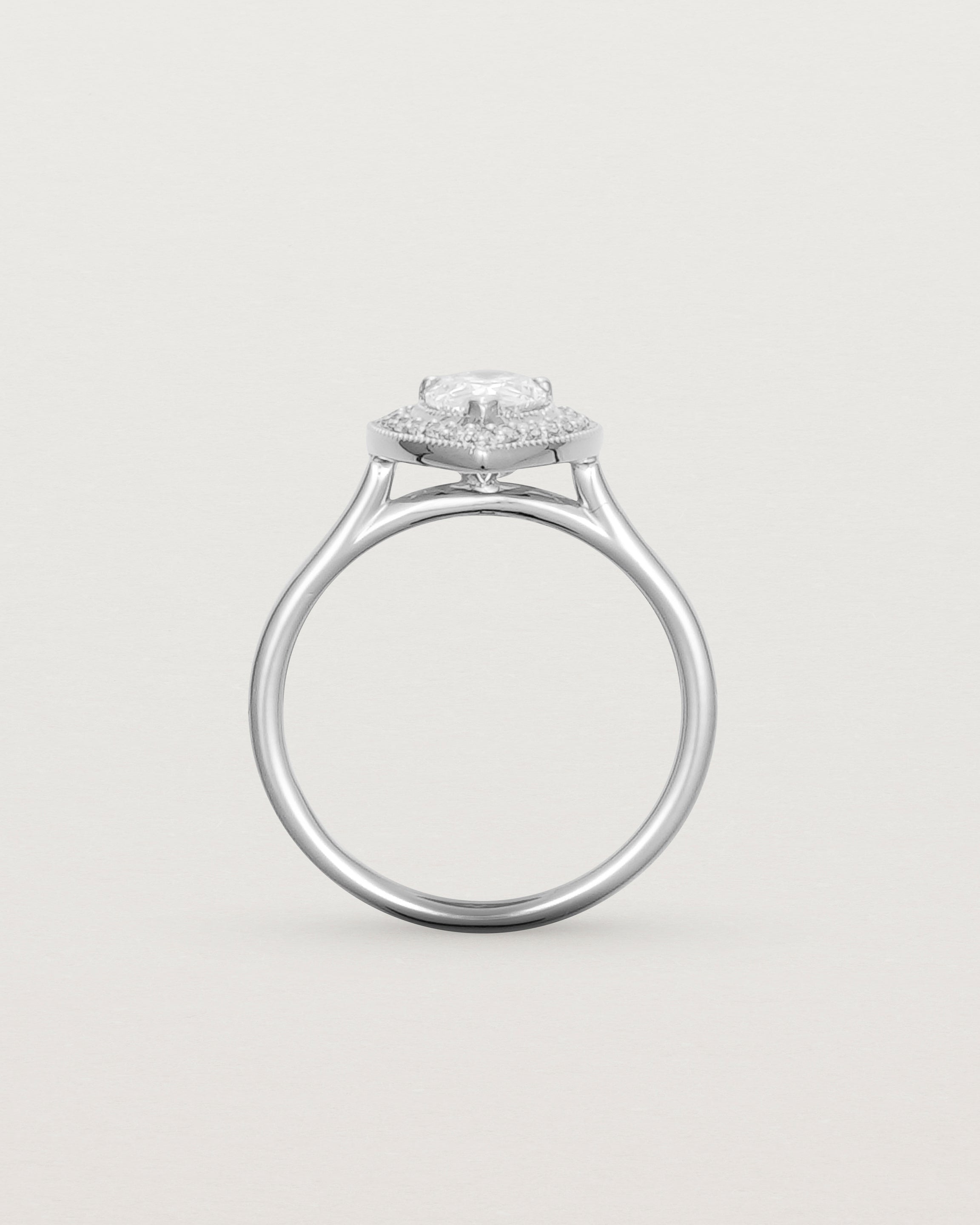 Standing view pear halo ring featuring a pear cut clear laboratory grown diamond and a halo of white diamonds in white gold