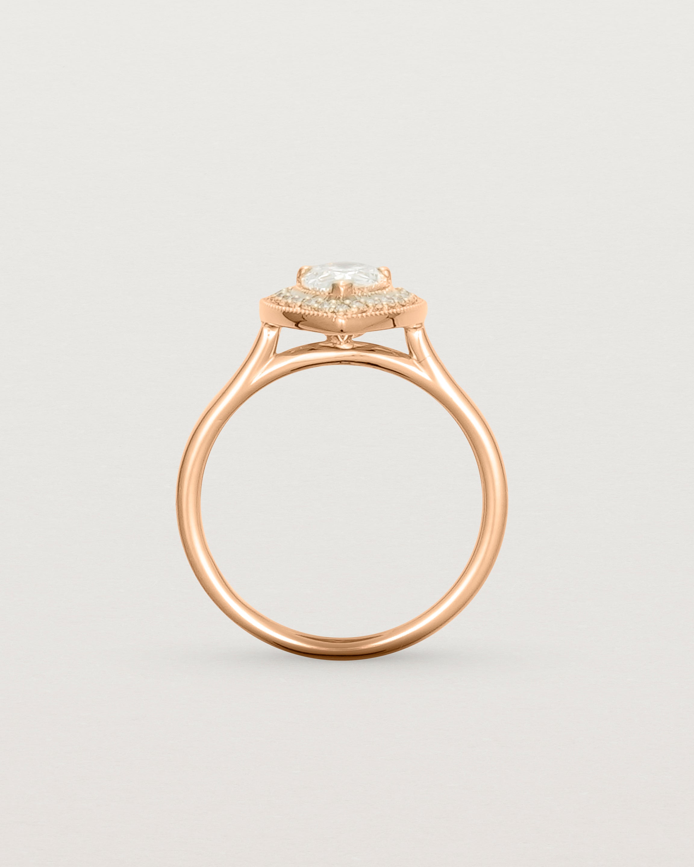 Standing view pear halo ring featuring a pear cut clear laboratory grown diamond and a halo of white diamonds in rose gold