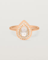 Front view pear halo ring featuring a pear cut pale pink morganite and a halo of white diamonds in rose gold