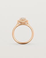 Standing view pear halo ring featuring a pear cut pale pink morganite and a halo of white diamonds in rose gold