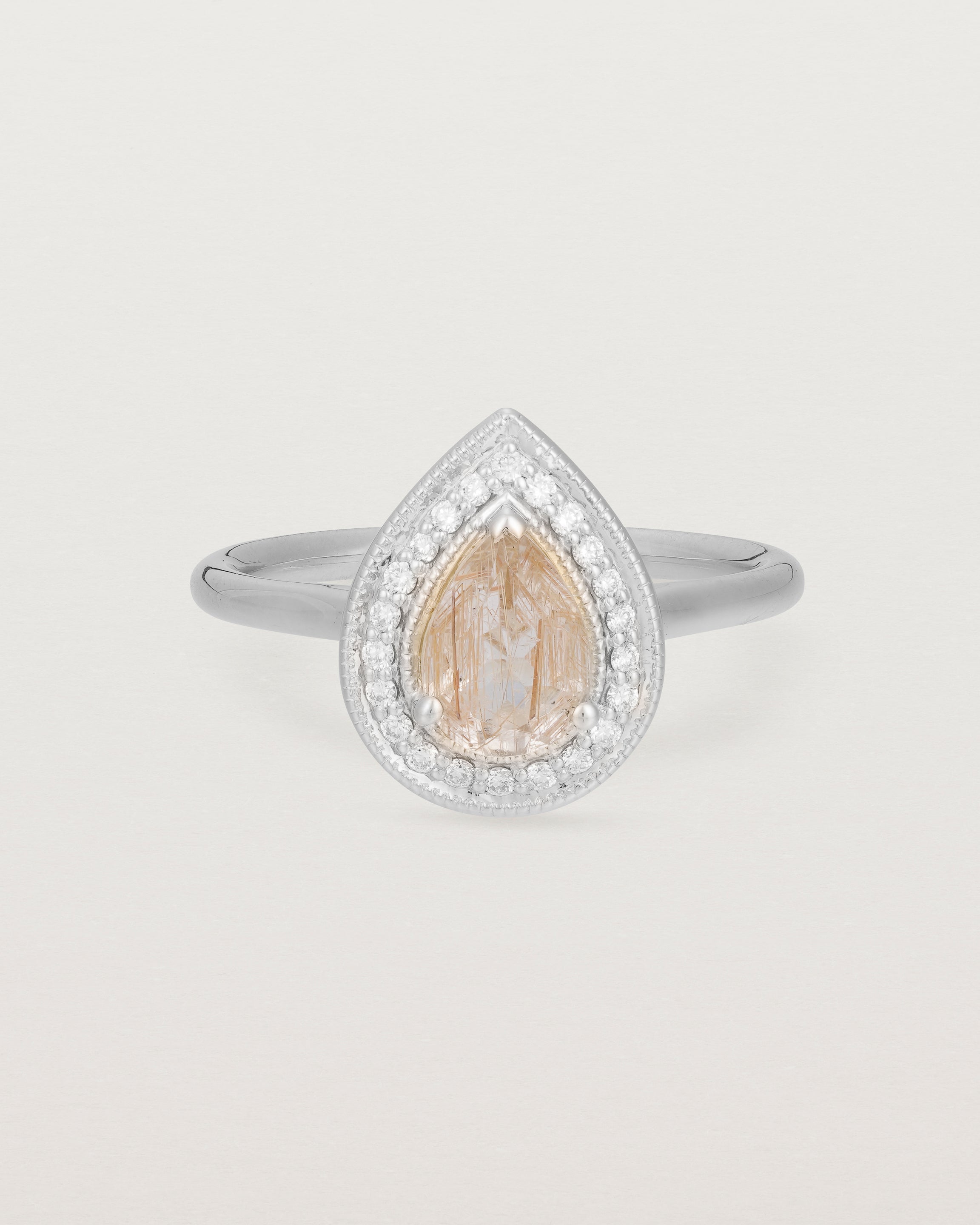 Front view pear halo ring featuring a pear cut rutilated quartz stone and a halo of white diamonds in white gold