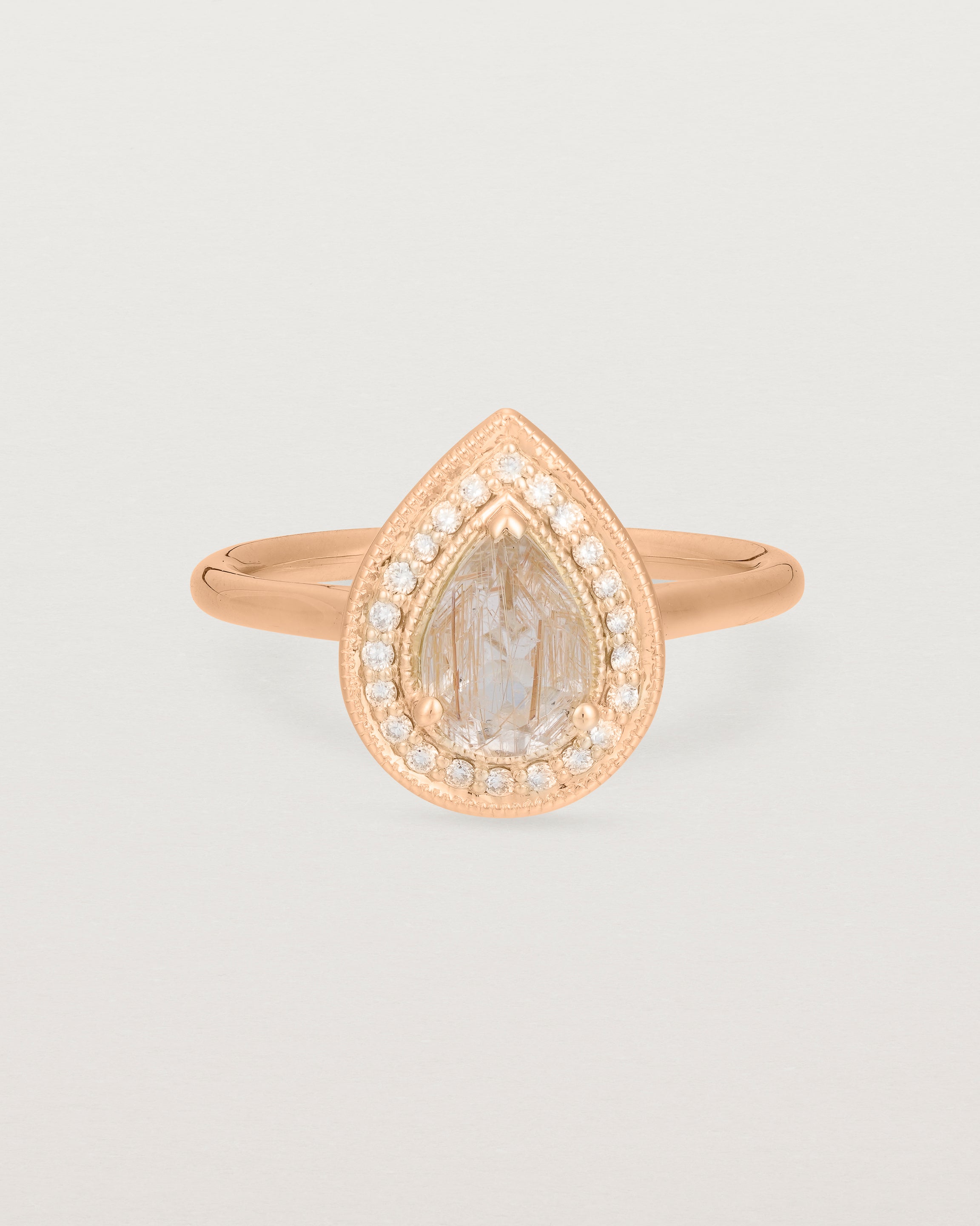 Front view pear halo ring featuring a pear cut rutilated quartz stone and a halo of white diamonds in rose gold