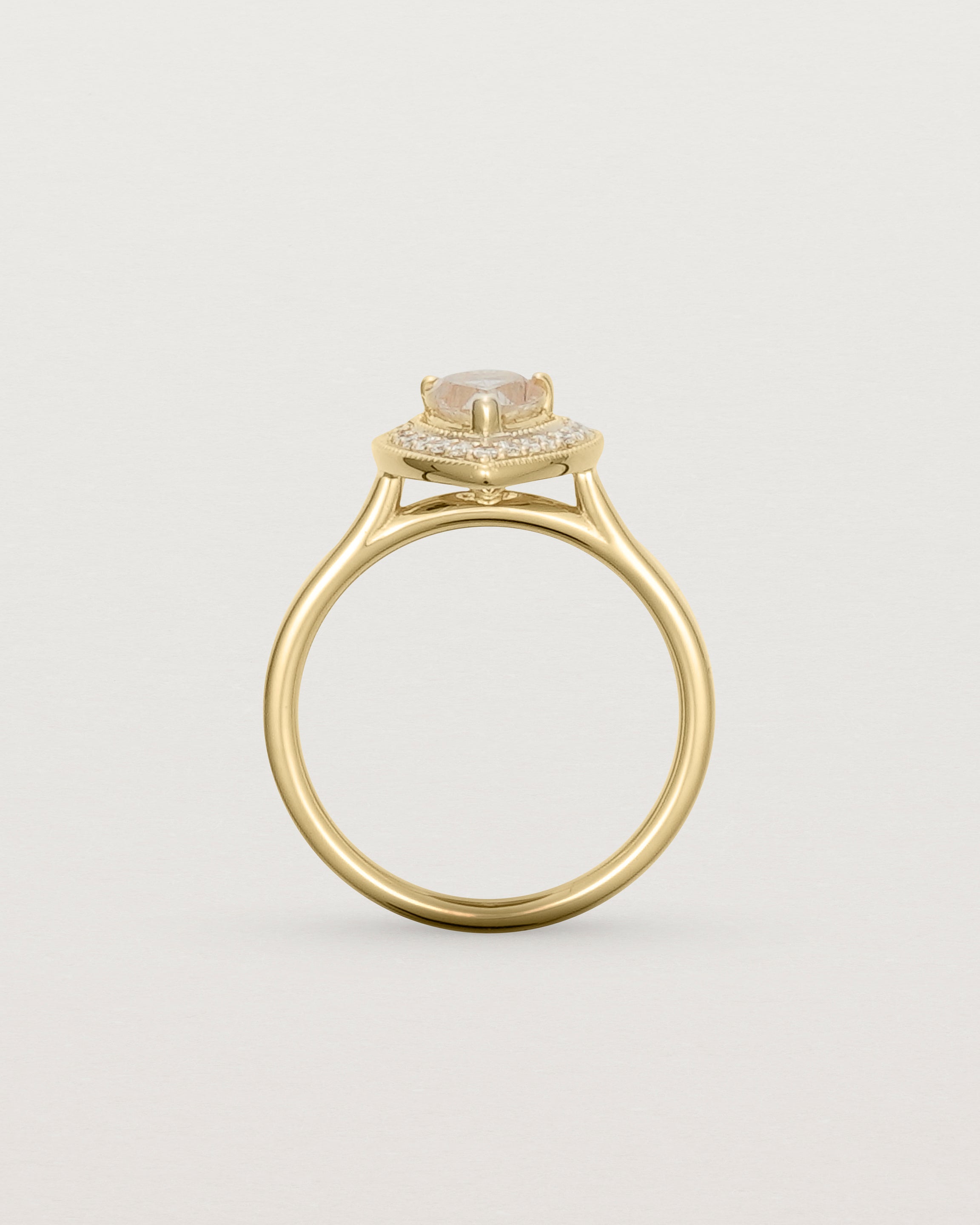 Standing view pear halo ring featuring a pear cut rutilated quartz stone and a halo of white diamonds in yellow gold