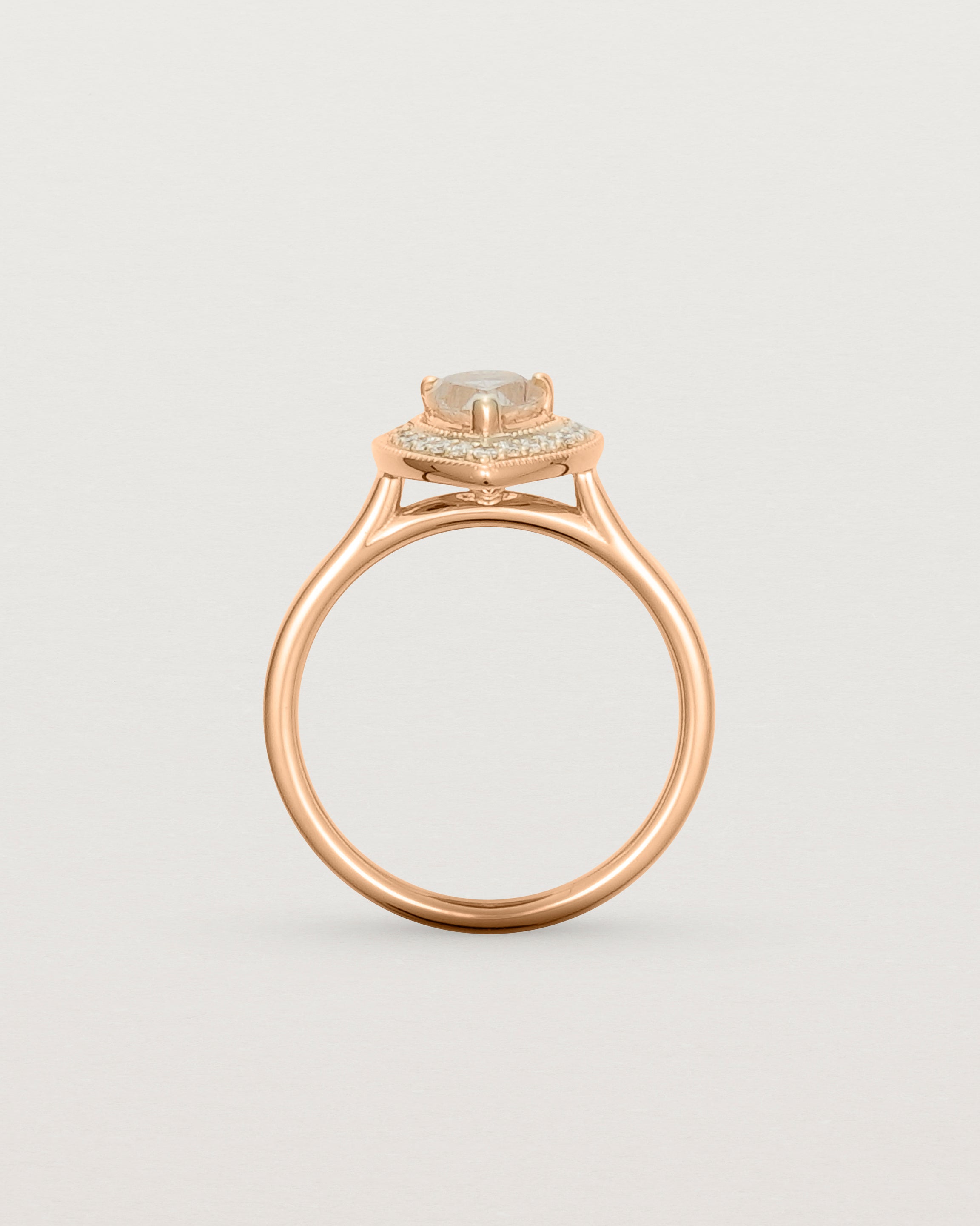 Standing view pear halo ring featuring a pear cut rutilated quartz stone and a halo of white diamonds in rose gold