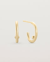 A small pair of yellow gold open hoops with a gold ball in the centre