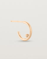 A small pair of rose gold open hoops with a gold ball in the centre