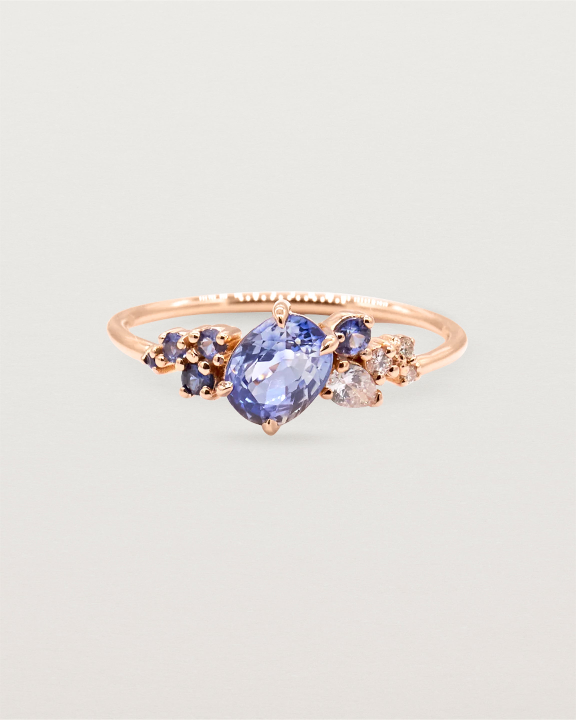 Blue sapphire cluster featuring oval and round sapphires, crafted in rose gold