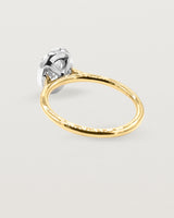The back view of a diamond halo ring crafted in yellow gold and white gold