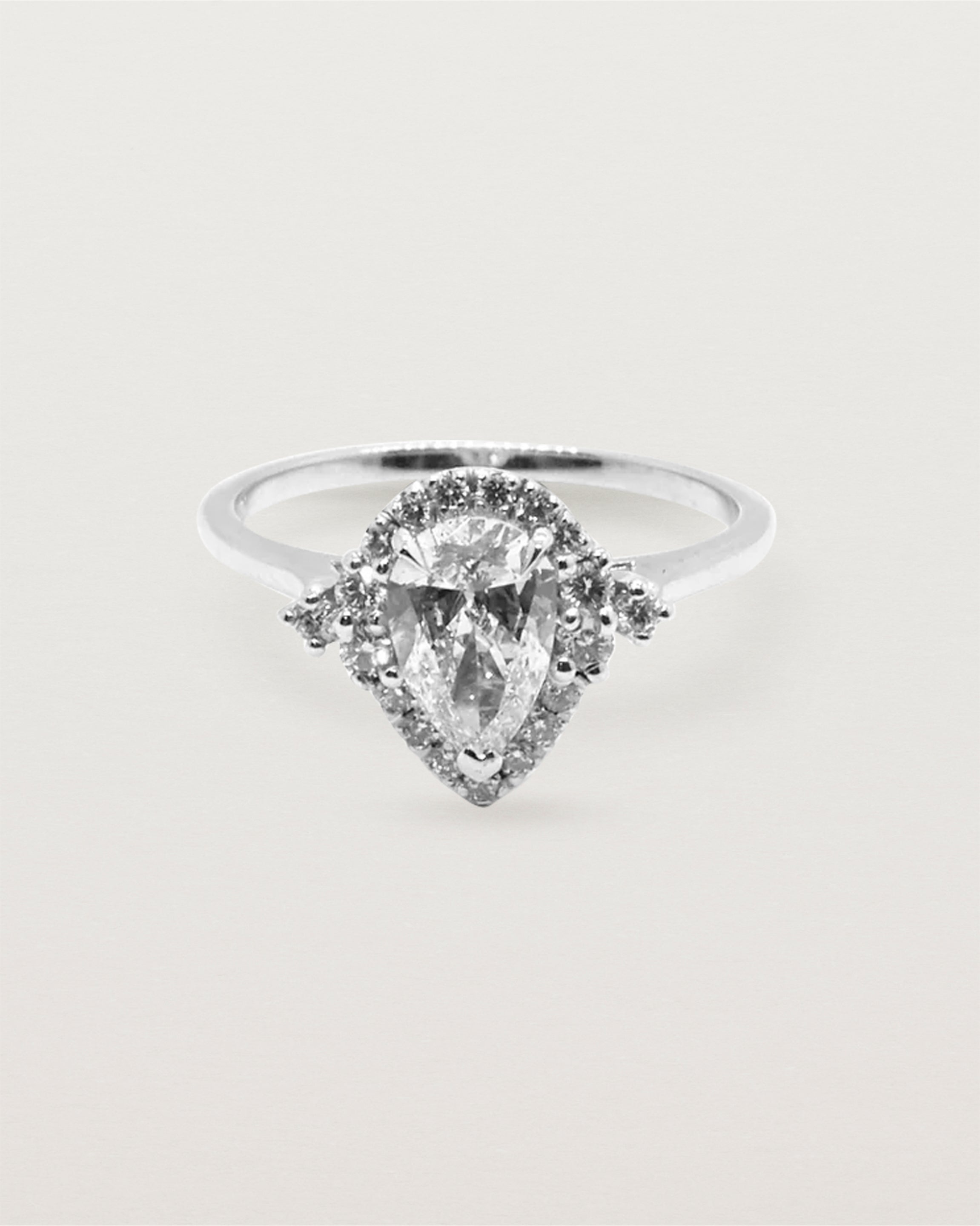 A pear cut diamond, framed by a halo of white diamonds crafted in white gold.