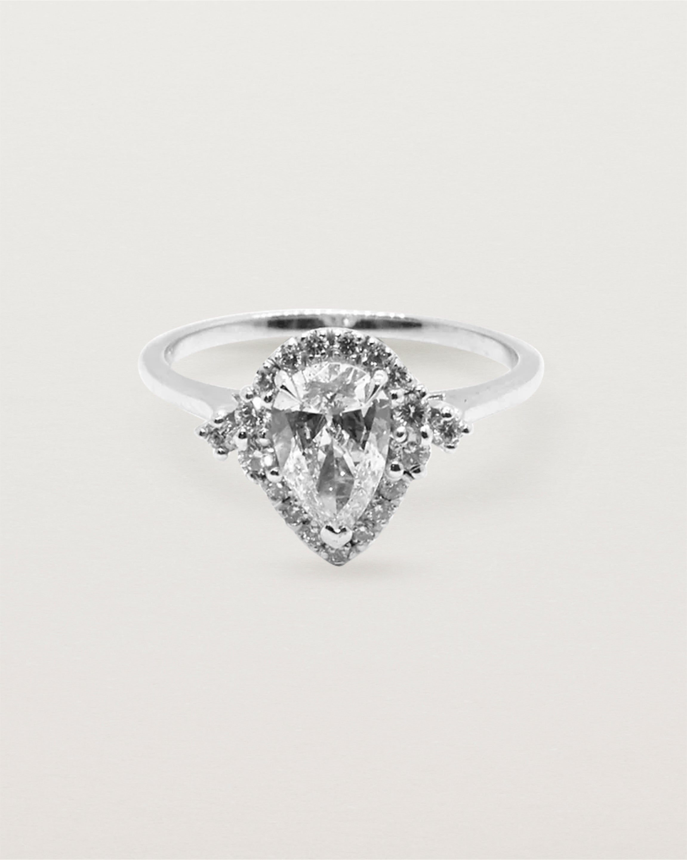 A pear cut diamond, framed by a halo of white diamonds crafted in white gold.